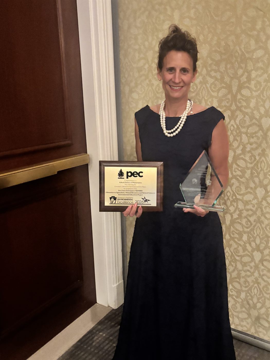 Dr. Mandy Manna holding the 2026 Governor's Award for Environmental Excellence plaque and trophy
